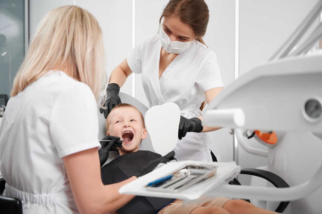 dentist-assistant-examining-child-teeth-dental-office
